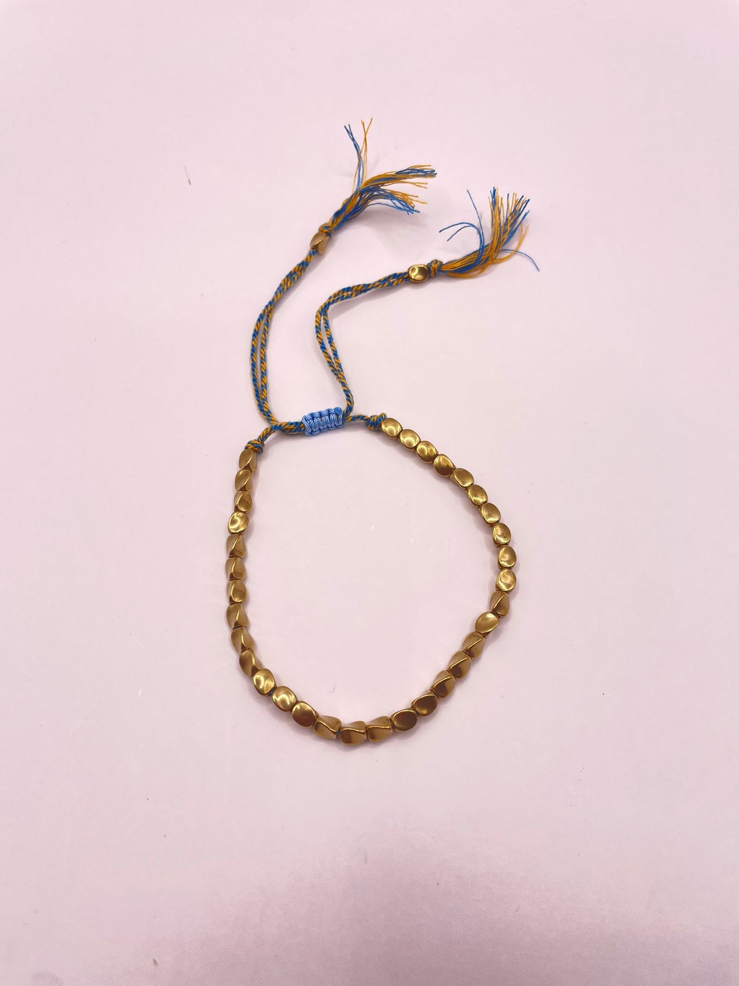 Verstelbare armband omhult met goudkleurige kralen